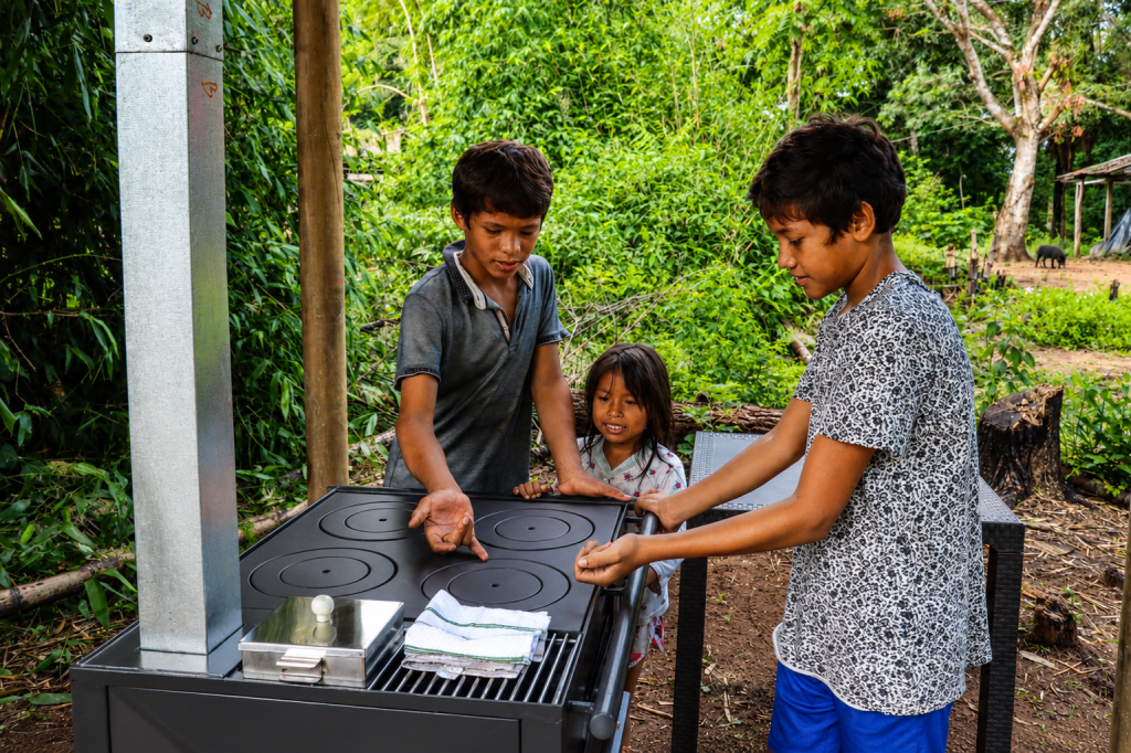 comunidad rural colombiana utilizando una estufa ecoeficiente Ergonatura con hornillas limpias y tecnología de combustión eficiente.